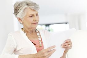 Senior woman reading documents pertaining to her deceased spouse's IRA