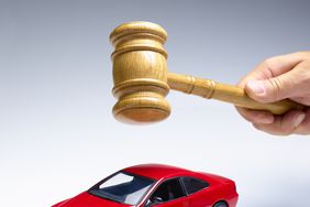 Gavel being held above a car
