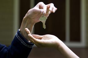 Detail of realtor handing keys to new home owner