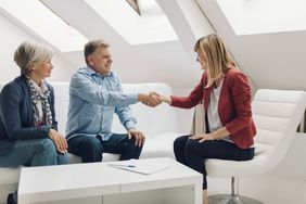 Mature couple meeting with a financial advisor in a casual white office