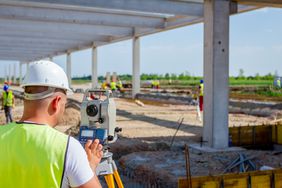 Civil engineer working with total station on a building's property site location