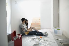 Asian couple painting their home