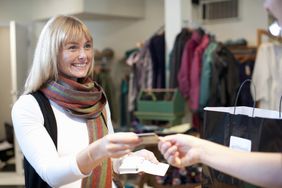 Woman pays for clothing purchase with credit card