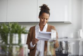 woman reading a document in her kitchen