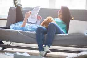 Concentrating young couple examining tax papers while relaxing on sofa at home