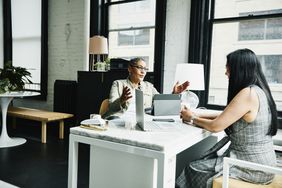 Female business advisor at desk with female business owner