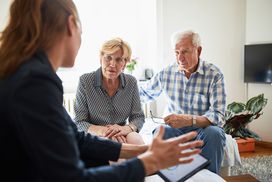 elderly couple at home meeting with an advisor