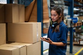 Warehouse worker updating stock in a mobile app