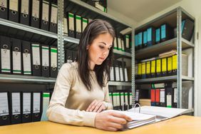 A woman looks through documents as part of a title search