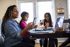Mother working from home while daughters homeschool 