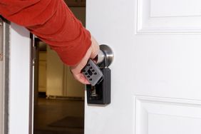 Man opening door to house with key lockbox on handle