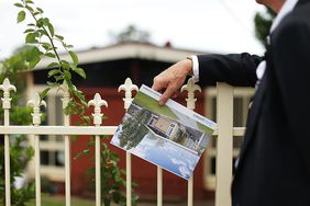 Man in suit looking at house for sale