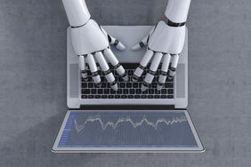 robot hands typing on a laptop keyboard representing day trading futures.