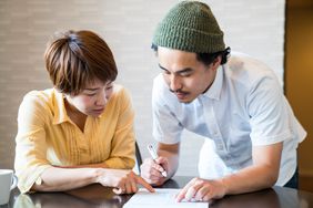 Young married couple filling out important paper documents