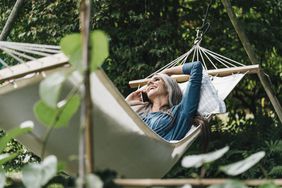 A person in a hammock talks on the phone.