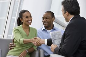 Couple shaking hands with a businessman