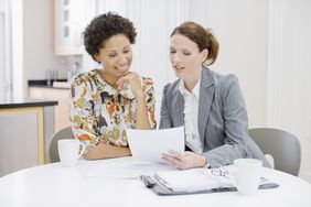 Woman reviewing loan paperwork with lender