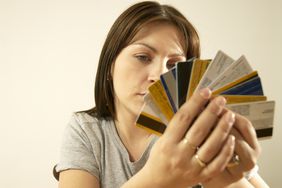 Woman looking overwhelmed by all her credit cards