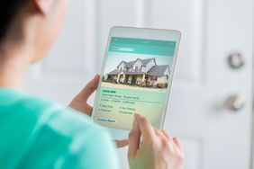 Woman using tablet to look at houses for sale online