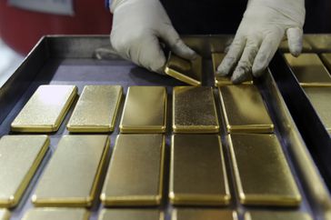 An employee arranges one kilogram gold bars at a mint refinery in Australia.