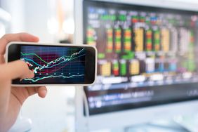 Checking stock prices on a smartphone and on a computer.