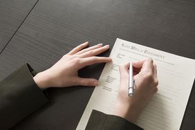 Closeup of a woman's hands signing a last will and testament