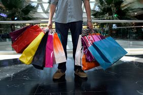 Man holding many shopping bags in mall after a spending spree