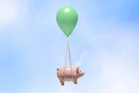 Piggy bank being carried by balloon