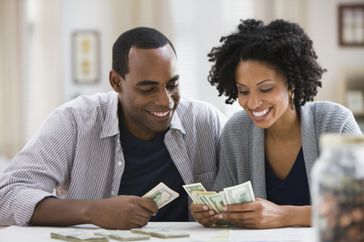 Couple counting money at a table at home