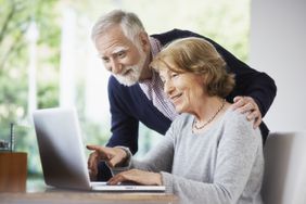A senior couple at home using a computer.