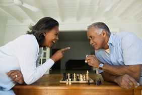 Man and woman smiling over chess game