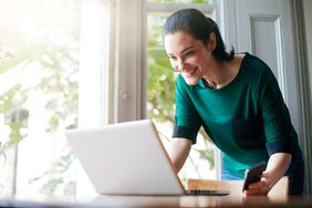 Smiling woman looking at her laptop