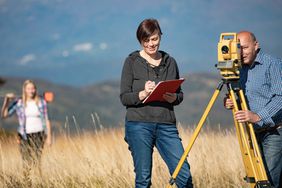 Surveyors Measuring Land in Rural Scene