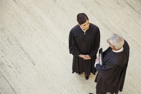Overhead view of two judges talking in a courthouse corridor