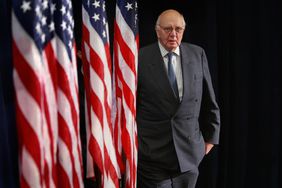 Paul Volcker next to American flags