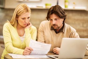 Couple reviewing their credit card statement and worrying that the balance is wrong.